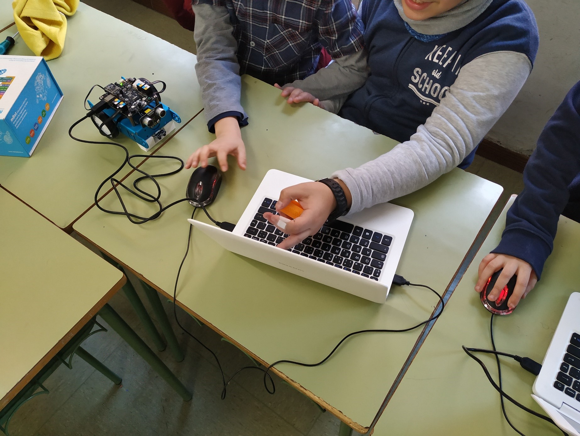Alumnos de Roboticole programando robot mBot
